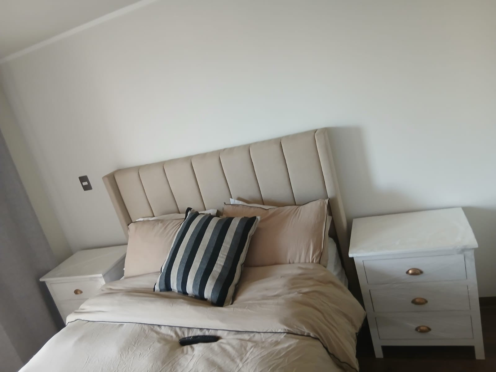 Veladores Regatta blancos instalados junto a la cama de un cliente.