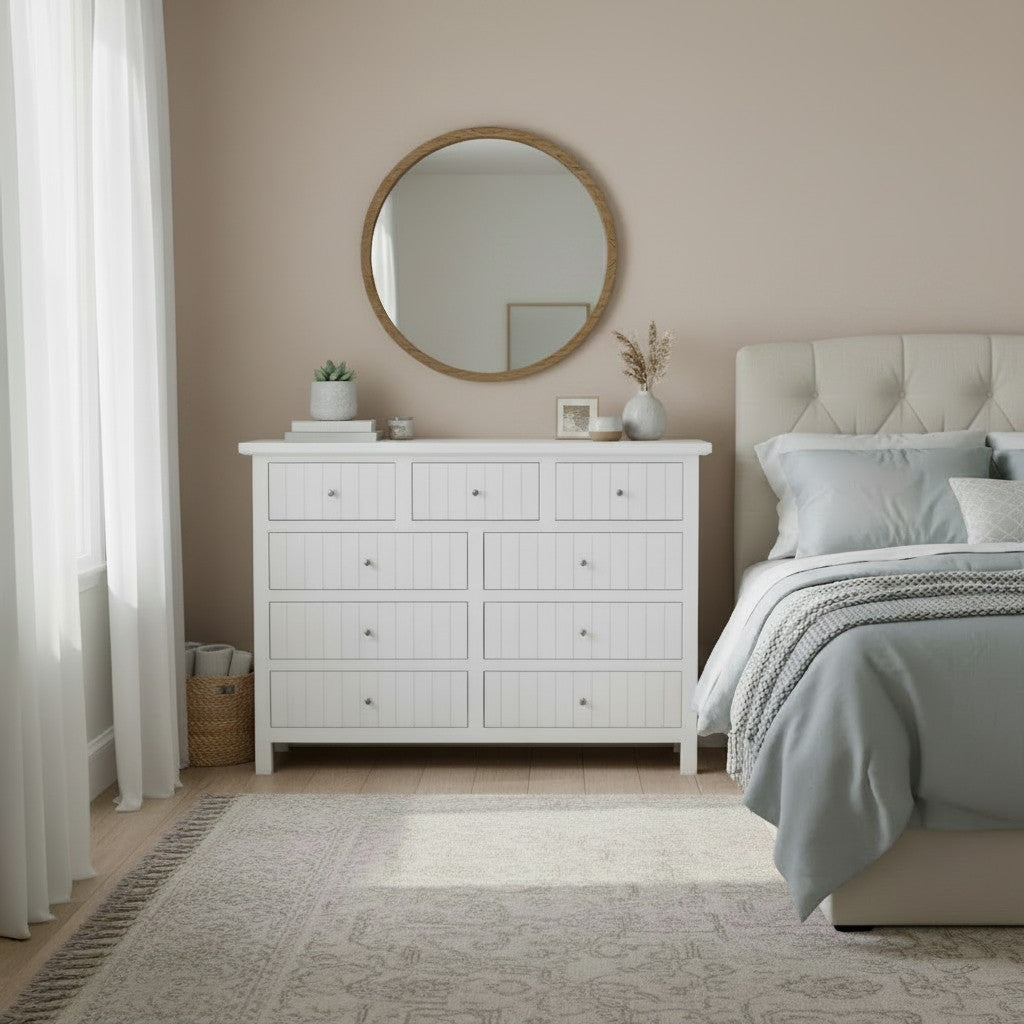 Cómoda Aval Ranurada de MGR Muebles en color blanco con 9 cajones, diseño rústico y espejo redondo en dormitorio.