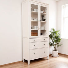 Vista lateral de vitrina de madera blanca con tiradores y compartimentos cerrados

